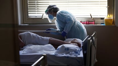 Una sanitaria asiste a una persona infectada con covid-19 en el Hospital Gregorio Marañón de Madrid.
