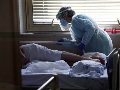 Una sanitaria asiste a una persona infectada con covid-19 en el Hospital Gregorio Marañón de Madrid.