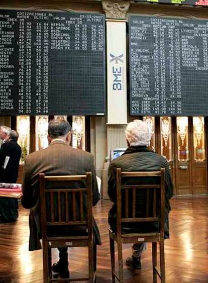 Dos inversores miran los paneles informativos de la Bolsa de Madrid.