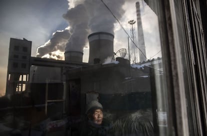 Una mujer de 83 años, de la ciudad china de Shanxi, observa desde la ventana de su casa la central de carbón.