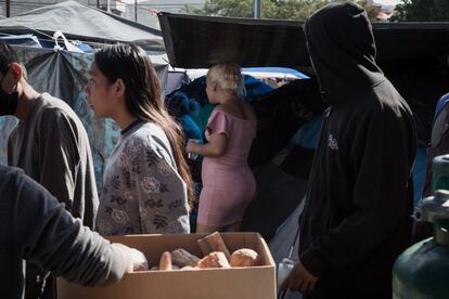 Adultos y niños esperan su turno para merendar.