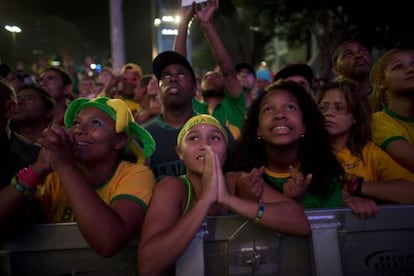 Torcedores brasileiros assistem &agrave; sele&ccedil;&atilde;o em um tel&atilde;o.