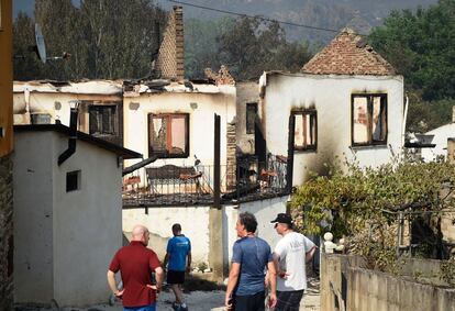 Los aldeanos observan las casas quemadas tras un incendio forestal en A Veiga de Cascalla (Orense), el 19 de julio de 2022.