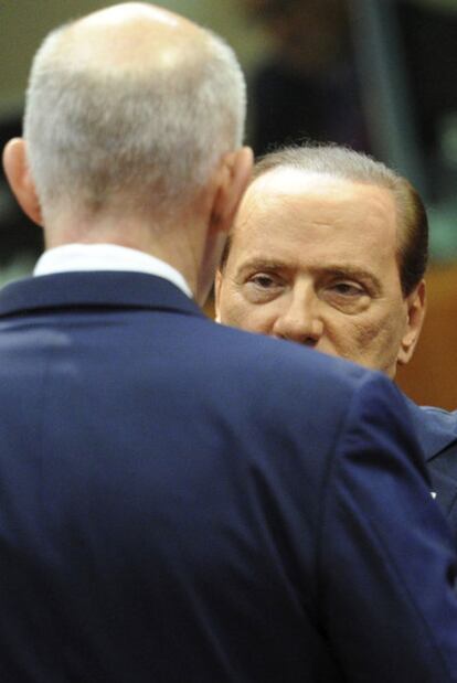 El expresidente italiano Silvio Berlusconi conversa con Giorgios Papandreu (de espaldas), expresidente griego.