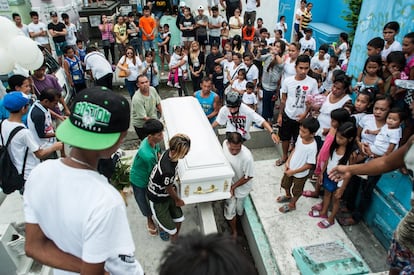 Familiares de un presunto ladrón y traficante de drogas, víctima de una ejecución extrajudicial lloran durante el entierro de este en Manila.