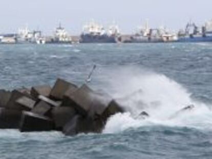 Barcos amarrados mientras las olas rompen con fuerza contra las piedras de la Avenida Mar&iacute;tima de Las Palmas de Gran Canaria, donde ya se empieza a notar los efectos del temporal de viento y lluvia.