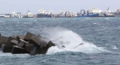 Barcos amarrados mientras las olas rompen con fuerza contra las piedras de la Avenida Mar&iacute;tima de Las Palmas de Gran Canaria, donde ya se empieza a notar los efectos del temporal de viento y lluvia.