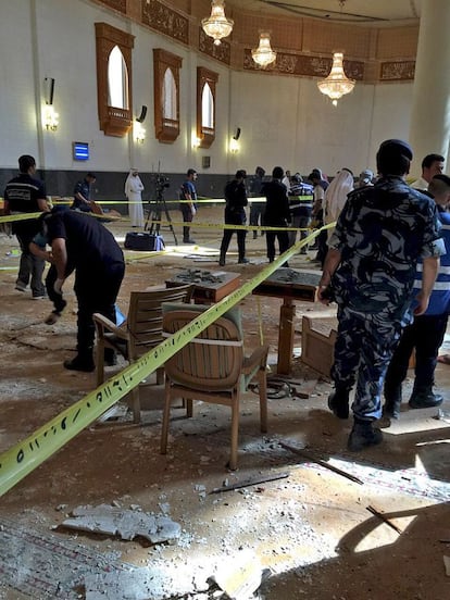 Policías y personal militar inspeccionan el interior de la mezquita Kuwait tras el atentado terrorista.