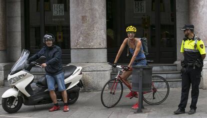 Un motorista, una ciclista i un policia a la Via Laietana