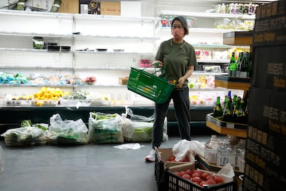 Una persona compra en un supermercado semivacío en Chaoyang, Pekín