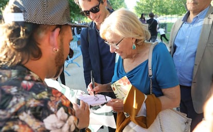 La alcaldesa de Madrid Manuela Carmena firmando un autógrafo en una de las pancartas de su candidatura ayer a orillas del Manzanares (Madrid).