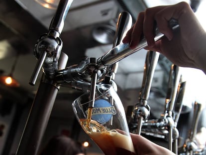 Una camarera sirve una cerveza en un bar de Madrid.