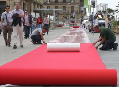 Unos operarios montan la alfombra roja del teatro Victoria Eugenia, en la última edición del certamen de San Sebastián.