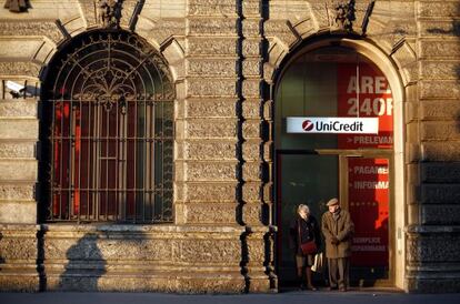 Dos personas, ante la oficina central de Unicredit en Milán.