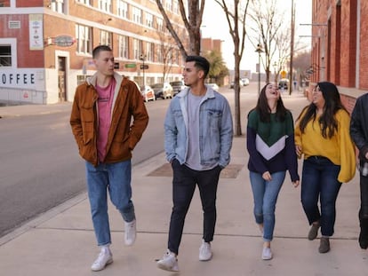 Cinco adolescentes caminan por la calle. 
