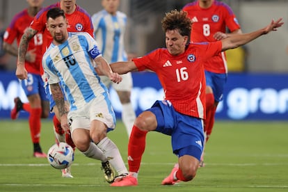 Chilean defender Igor Lichnovsky tries to steal the ball from Messi in the first half of the match.