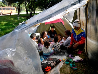 Migrantes venezolanos comen dentro de una carpa en un campamento improvisado en Bogotá, en junio de 2020.