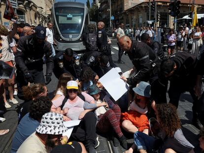 Manifestantes bloquean las vías del tren ligero exigiendo la liberación de los rehenes retenidos en Gaza, este domingo en Jerusalén.