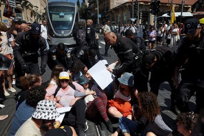 Manifestantes bloquean las vías del tren ligero exigiendo la liberación de los rehenes retenidos en Gaza, este domingo en Jerusalén.