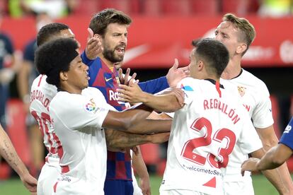 Piqué protesta una jugada rodeado de jugadores del Sevilla.