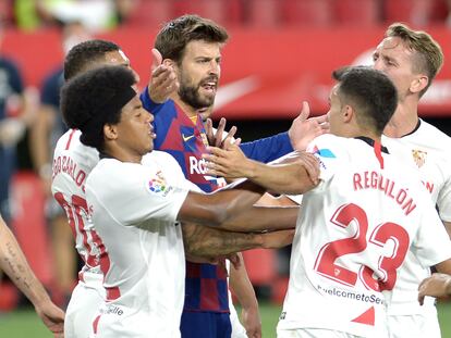 Piqué protesta una jugada rodeado de jugadores del Sevilla.