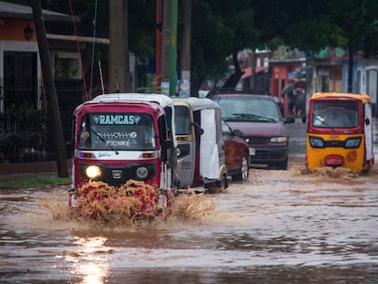 Personas transitan por una avenida inundada en el municipio de Tehuantepec, estado de Oaxaca, México, el 30 de mayo de 2022.