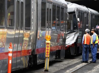 Dos trabajadores de la red de tranvías de San Francisco examinan los coches accidentados.