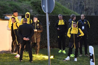 El entrenador del Borussia de Dortmund Thomas Tuchel y los jugadores permanecen fuera del autobús después del ataque que han sufrido.