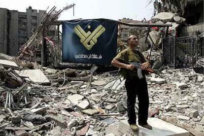 Un miliciano vigila las ruinas del edificio de la televisión Al Manar, de Hezbolá, en el sur de Beirut.