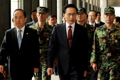 El presidente surcoreano, Lee Myung-Bak (centro), y el ministro de Defensa, Kim Tae-Young, se encaminan a una rueda de prensa ante el monumento conmemorativo de la Guerra de Corea, en la capital surcoreana.