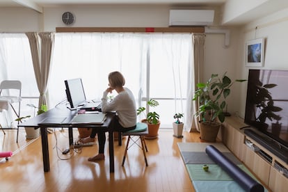 Una mujer teletrabaja desde el salón de su casa.