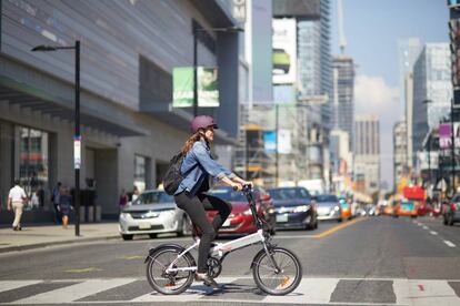 Una mujer cruza en bicicleta.