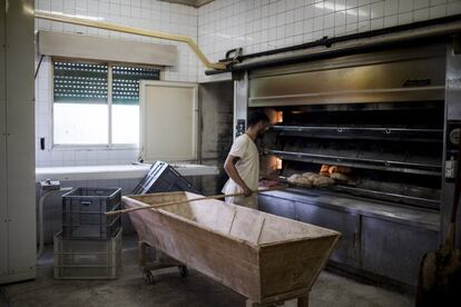 Un joven trabaja en una panadería en San Xoán de Río, propiedad del alcalde, que emplea a una docena de personas en una zona donde las oportunidades de trabajo son escasas.