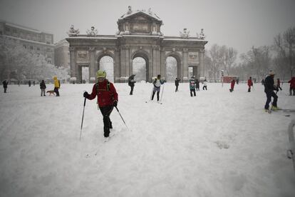 La cantidad de nieve caída ha sepultado las calles hasta el punto de no distinguir las aceras de las calzadas. En la imagen, varios vecinos esquían alrededor de la Puerta de Alcalá.