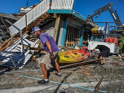 Trabajadores y residentes limpian los escombros de un bar destruido en la isla de San Carlos, en Fort Myers (Florida), este sábado.