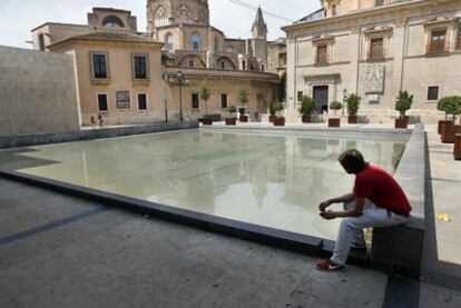 La lámina de agua sucia sobre el techo de cristal impide ver los restos de la Valencia antigua en L&#39;Almoina.