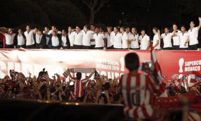 Los jugadores y el cuerpo técnico del Atlético de Madrid, subidos a una tarima en la plaza de Neptuno junto a su afición, celebran la victoria en la Supercopa de Europa.