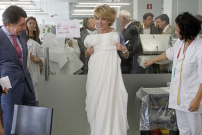 La presidenta de la Comunidad de Madrid, Esperanza Aguirre, muestra un vestido durante su visita al taller del reciente diseñador fallecido Jesús del Pozo.