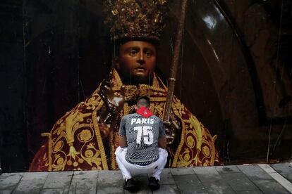 Un corredor reza frente a una imagen de San Fermín antes del encierro.