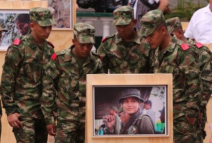 Soldados de Colombia observan la exposici&oacute;n fotogr&aacute;fica &quot;Caquet&aacute;: Mujeres, conflicto y territorio&quot; en la que aparece una guerrillera de las FARC.