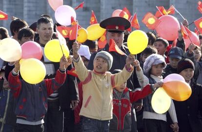 Varios niños observan el desfile de estudiantes del instituto de policía de Kirguizistánm durante los preparativos para las elecciones en Bishkek, la capital.