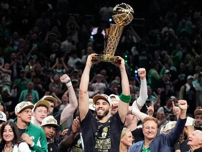 Jayson Tatum, en el centro, sostiene el trofeo tras el triunfo de los Celtics de Boston.