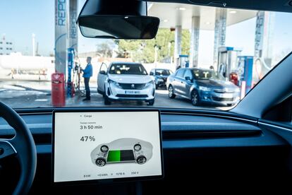 The interior of an electric car at a gas station.