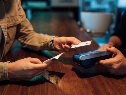 Un cliente paga con una tarjeta de crédito en un bar de Valencia.