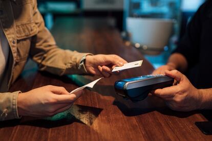 Un cliente paga con una tarjeta de crédito en un bar de Valencia.