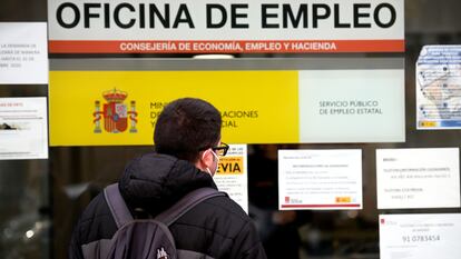 Un hombre mira el cristal de una oficina de empleo del SEPE (antiguo INEM) en Madrid, el pasado diciembre.