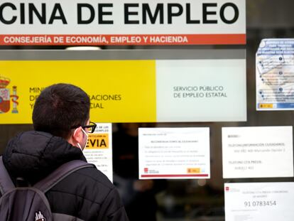 Un hombre mira el cristal de una oficina de empleo del SEPE (antiguo INEM) en Madrid, el pasado diciembre.