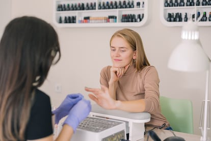 Una clienta revisa sus uñas en un centro de belleza.