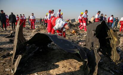 Trabajadores de la Media Luna Roja revisan los escombros del avión de Ukraine International Airlines, en las afueras de Teherán.