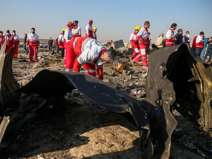 Trabajadores de la Media Luna Roja revisan los escombros del avión de Ukraine International Airlines, en las afueras de Teherán.